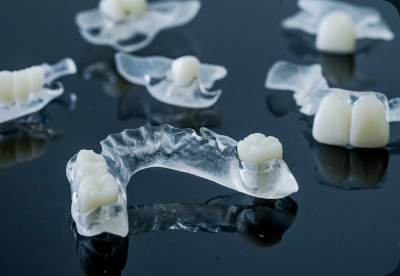 Clear flexible partial dentures on a dark surface