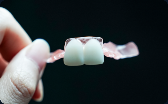 A finished flexible partial denture held between fingers